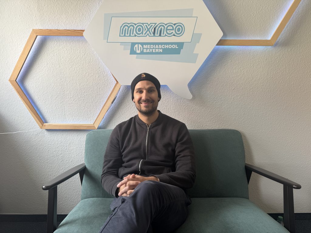 Auf einem Sofa sitzt Sänger Simon. 