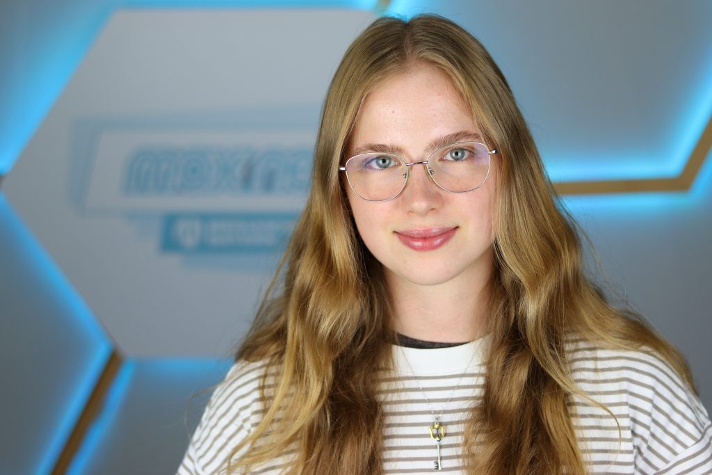 Das Foto zeigt Lisa Dunkel im Porträt vor dem max neo Logo.