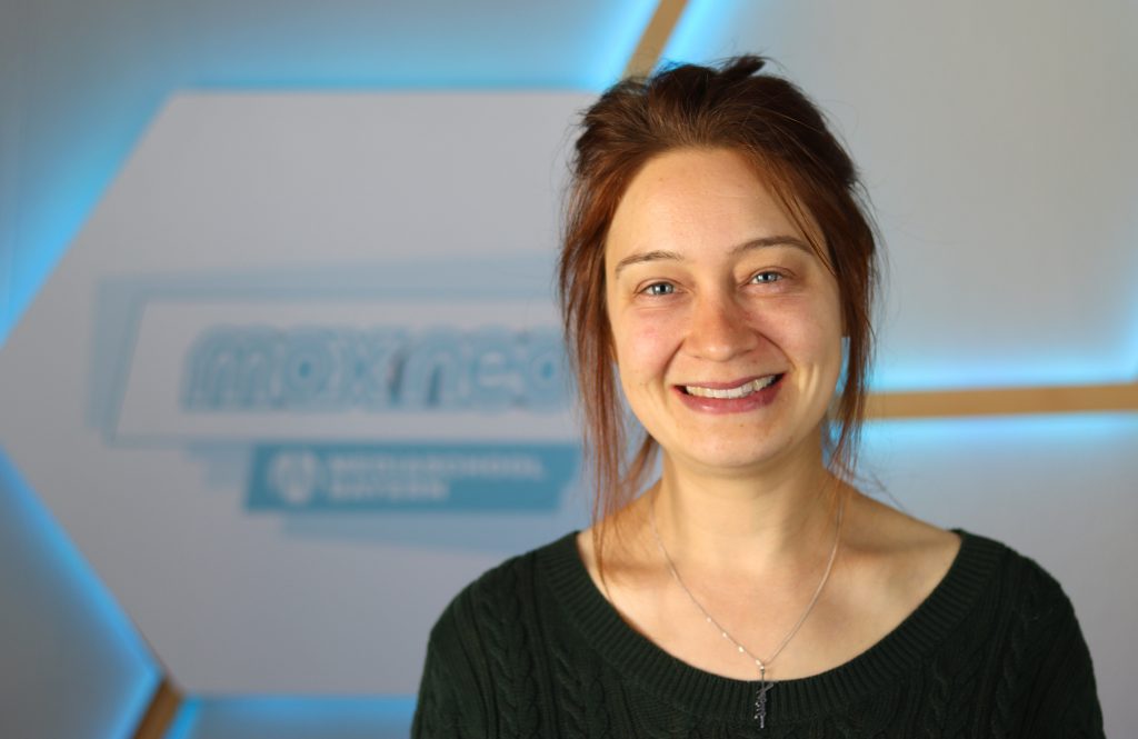 Das Foto zeigt Lisetta Jan im Porträt vor dem max neo Logo.